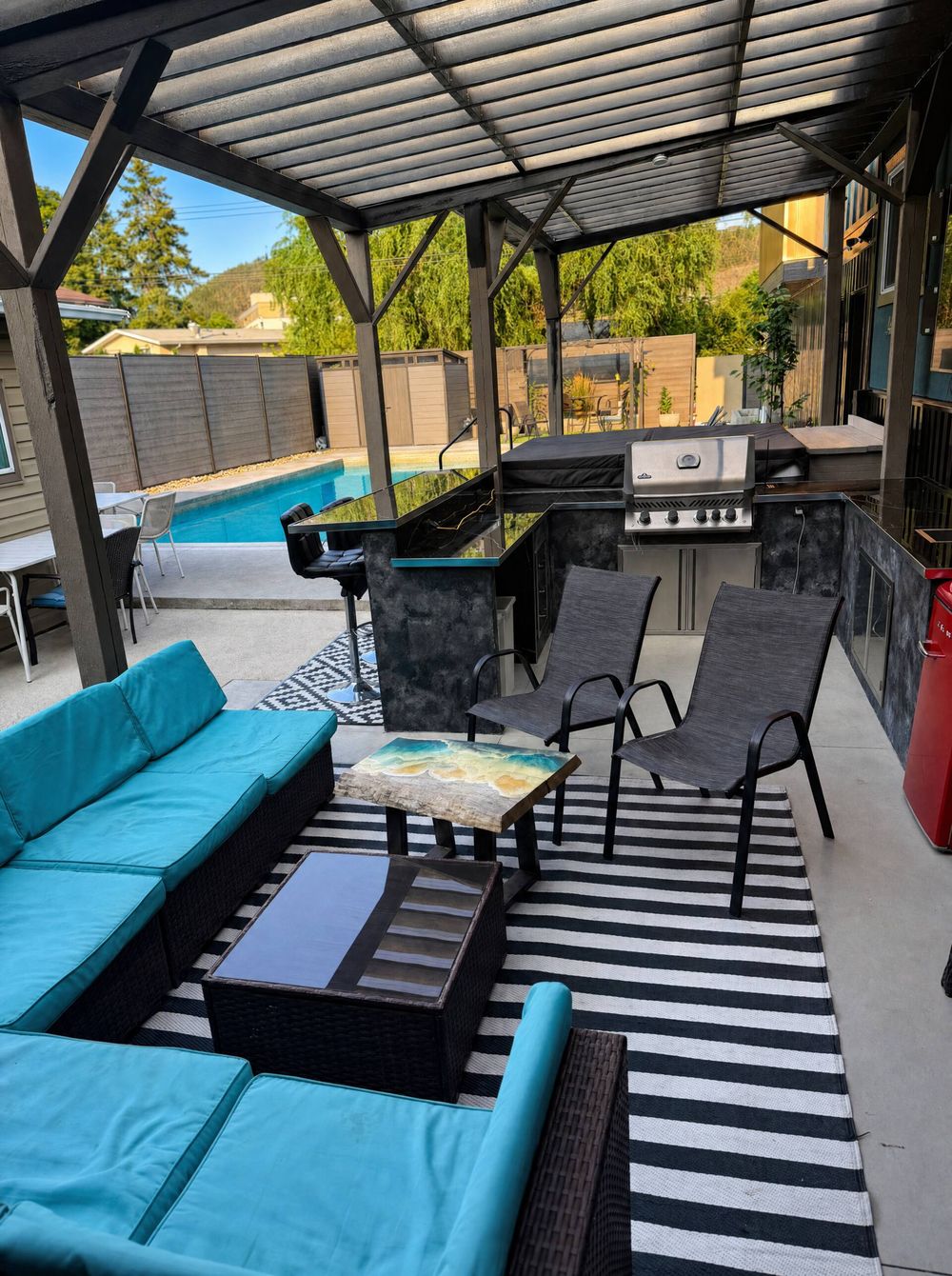 Covered poolside lounge and outdoor kitchen